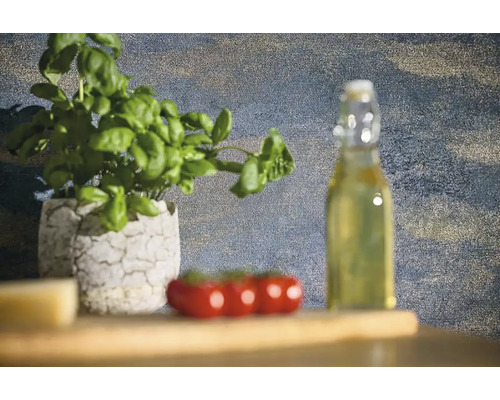 Stilleven met basilicumplant in een pot, tomaten en een fles olie op een houten tafel.