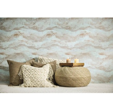 Woonkamer met gedessineerd behang, sierkussens en een poef