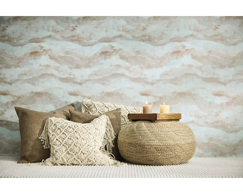 Woonkamer met gedessineerd behang, sierkussens en een poef