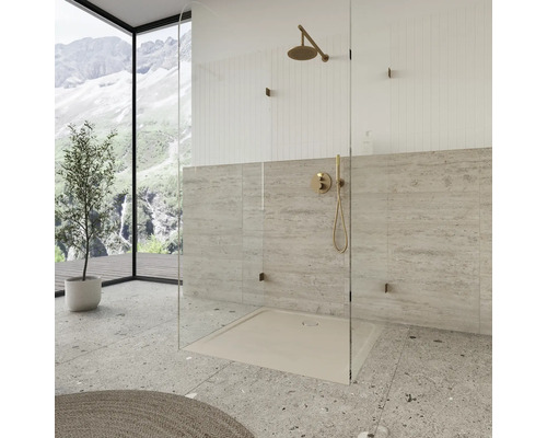 Inloopdouche met stortdouche, douchebak en glazen wand in een lichte badkamer.