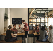 Scène in een restaurant met gasten aan tafels en een ober die bestellingen opneemt.