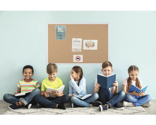 Vijf kinderen zitten voor een prikbord en lezen boeken.