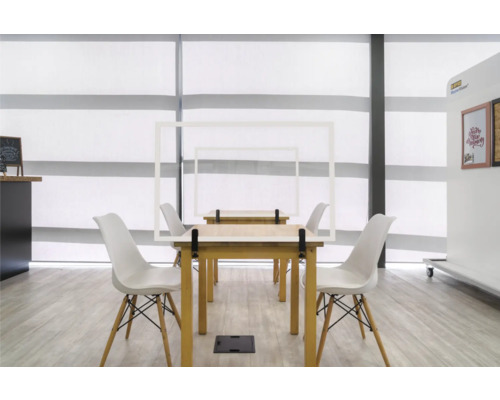 Ruimte met tafels, stoelen en beschermende frames voor sociale afstand
