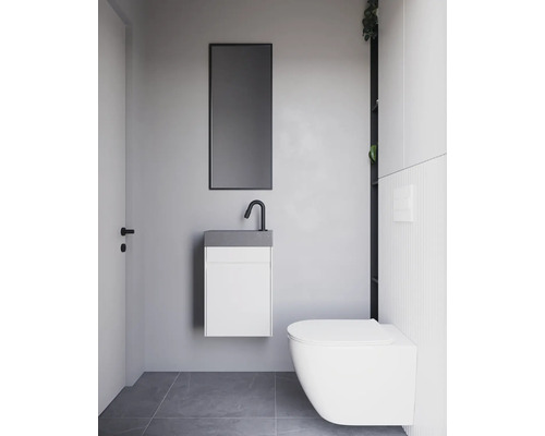 Moderne badkamer met hangende wastafel, spiegel en wandcloset.