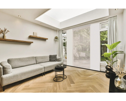 Woonkamer met bank, houten planken en daglicht