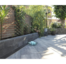 Tuinscene met straatstenen, banden en beplanting