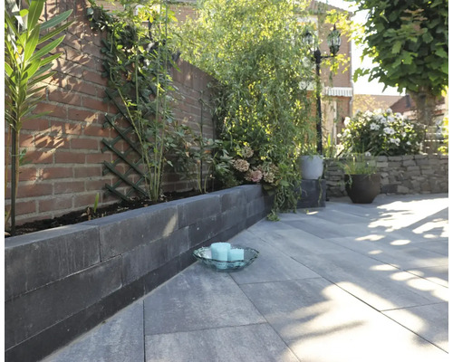 Tuinscene met straatstenen, banden en beplanting