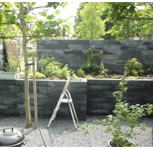 Aangelegde tuin met kruiden en planten in verhoogde stenen plantenbakken