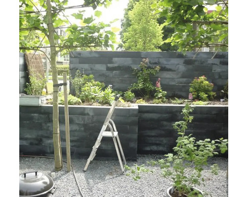 Aangelegde tuin met kruiden en planten in verhoogde stenen plantenbakken