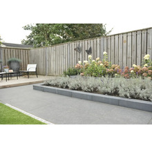 Aangelegde tuin met plantenperk, houten schutting en tuinmeubilair