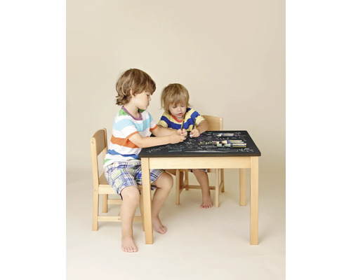 Twee kinderen zitten aan een kindertafel met stoelen en tekenen met stiften op het tafelblad.