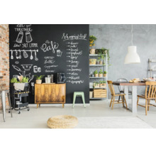 Eetkamer met schoolbordmuur, houten tafel en rekken met planten