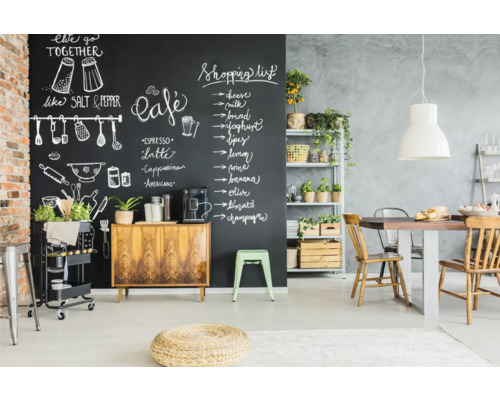 Eetkamer met schoolbordmuur, houten tafel en rekken met planten