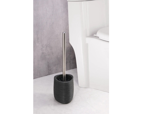 Toiletborstel met houder van aardewerk en roestvrijstalen steel naast een toilet
