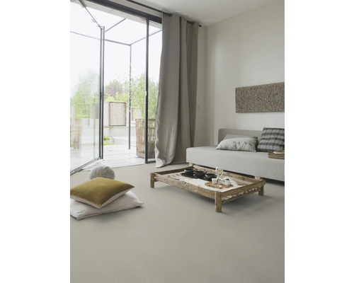 Woonkamer met bank, houten tafel, kussens en gordijnen voor een lichte en vriendelijke sfeer.