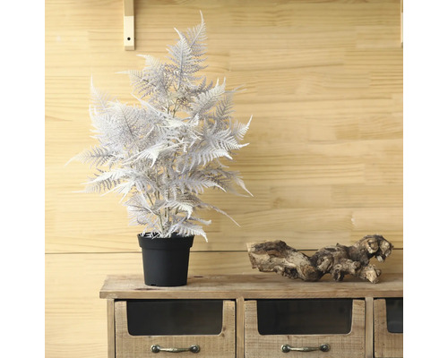 Decoratieve kunstvaren in pot op een houten kast.