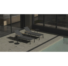 Twee ligstoelen en een bijzettafel naast een zwembad