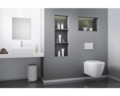 Moderne badkamer met wastafel, spiegel, toilet en decoratieve nissen.