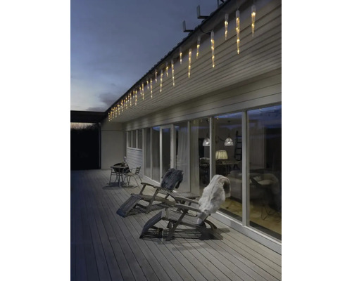 Buitenscène met ijspegelverlichting, ligstoelen en decoratie
