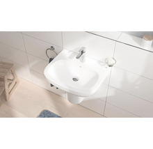 Compacte badkamer met hangende wastafel, kraan, handdoekhouder en zeepbakje.