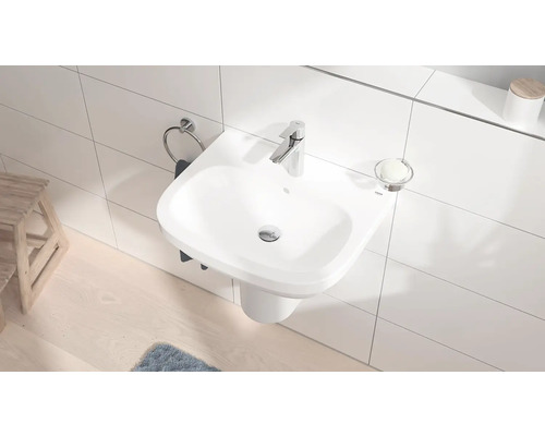 Compacte badkamer met hangende wastafel, kraan, handdoekhouder en zeepbakje.