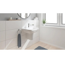 Lichte badkamer met opzetwastafel, handdoekring en raam voor een moderne sfeer.