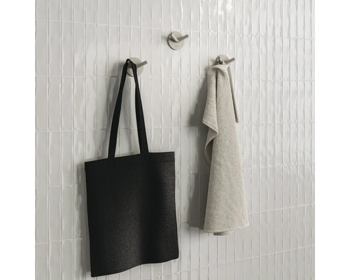 Wandtegels met handdoekhaken, handdoek en stoffen tas
