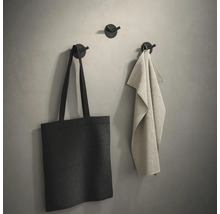 Wandhaken met tas en handdoek aan een muur