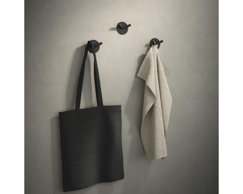 Wandhaken met tas en handdoek aan een muur