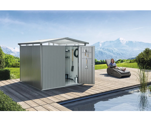 Metalen tuinhuis met open deur en gereedschap aan de binnenkant van de deur op een houten terras naast een zwembad