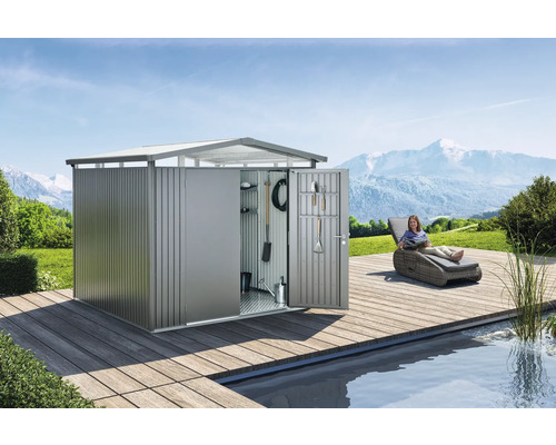 Tuinhuis met open deuren, gereedschap en vrouw op ligstoel in de tuin