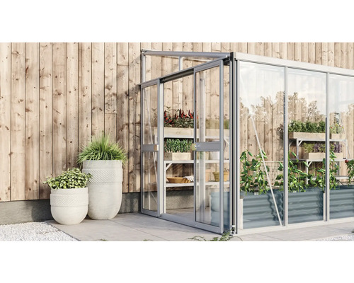 Kas met planten en plantenbakken voor een houten wand