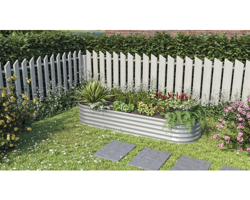 Metalen plantenbak met planten en bloemen in de tuin.