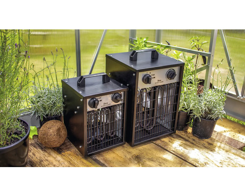 Twee broeikasverwarmers met een vermogen van 2 kilowatt en 3 kilowatt naast potplanten