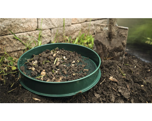 Tuinzeef met aarde en schep in de tuin