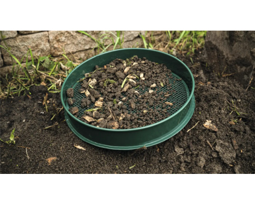 Tuinzeef met aarde en plantenresten op de grond