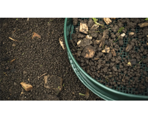 Aarde wordt gezeefd door een tuingaas