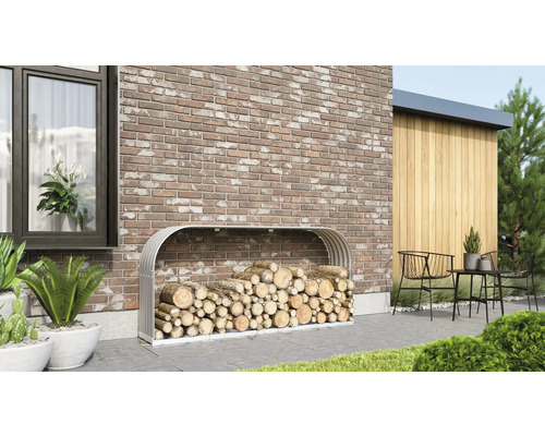 Met brandhout gevulde metalen houtopslag voor een bakstenen muur