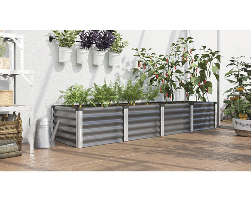 Metalen plantenbak met planten, kruiden en groenten op een terras.