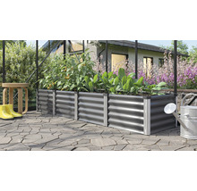 Metalen plantenbak met planten, gieter en regenlaarzen