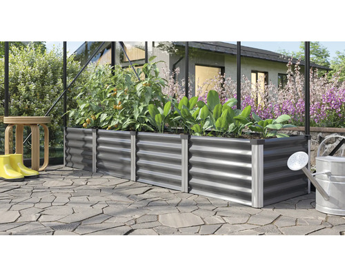 Metalen plantenbak met planten, gieter en regenlaarzen