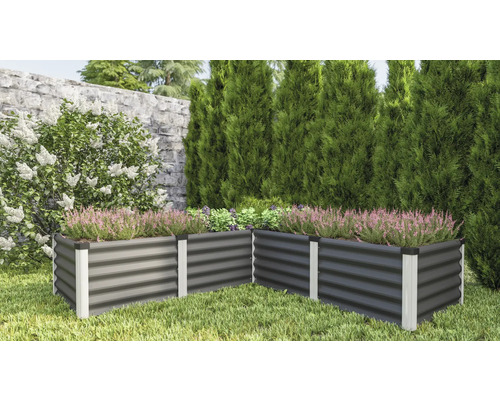Metalen verhoogde tuinbak in de tuin met planten