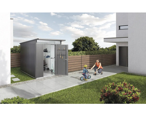 Metalen tuinhuis met open deuren, kind met fiets en een volwassene in de tuin