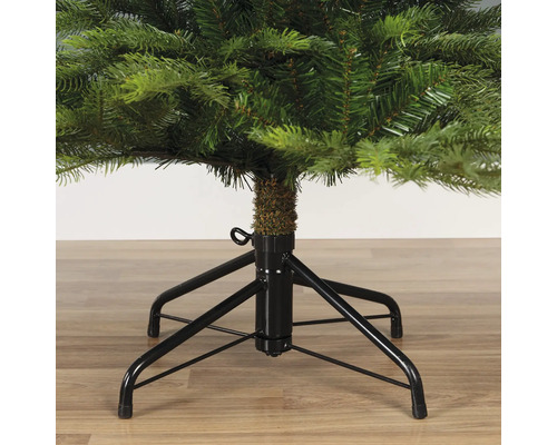 Detailopname van een kerstboom met een zwarte metalen voet