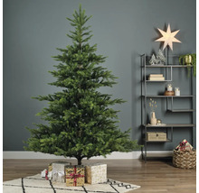 Versierde kerstboom met cadeaus in een woonkamer.