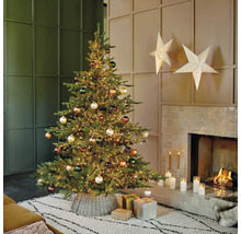 Versierde kerstboom met verlichting, kerstballen en cadeaus in de woonkamer