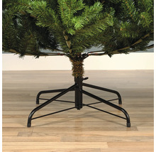 Detailopname van een kunstkerstboom met zwarte metalen voet.