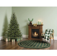 Woonkamer met kerstboom, open haard en fauteuil voor een feestelijke sfeer