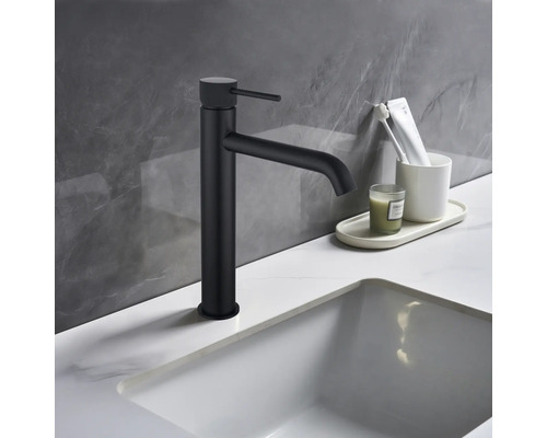 Zwarte wastafelkraan naast wastafel en badkamerbenodigdheden op wastafel