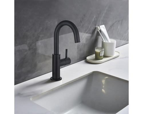 Zwarte wastafelkraan naast een wastafel in een badkamer.